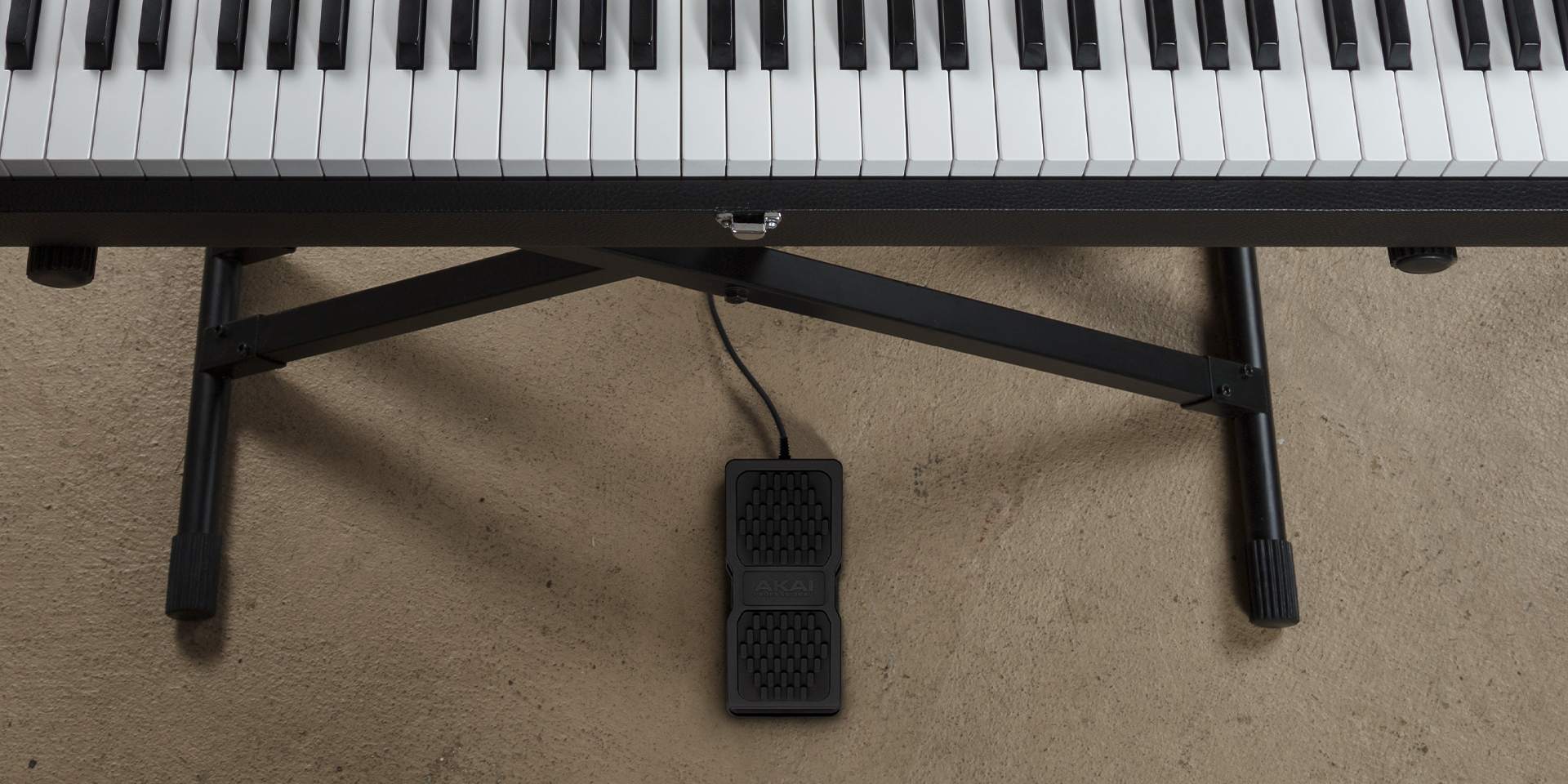 Composed wide shot of 88 key keyboard with expression pedal visible underneath